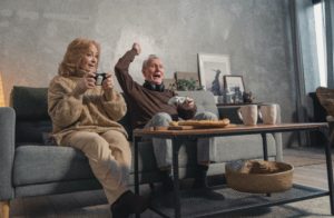 Femme et homme agés heureux qui jouent aux jeux vidéos
